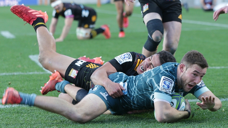 Mitch Hunt of the Highlanders beats Anton Lienert-Brown of the Chiefs to score a try