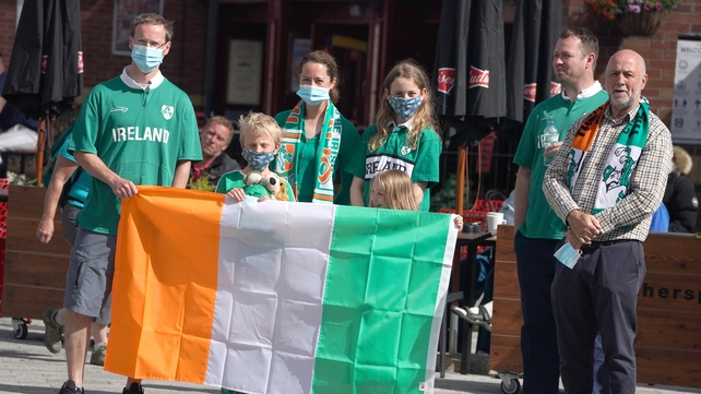 The Wilson family display the Irish colours as they wait for the funeral cortege in Ashington