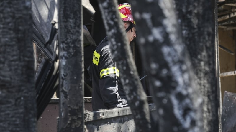 A firefighter pictured walking through the ruins in the days after the fire tragedy