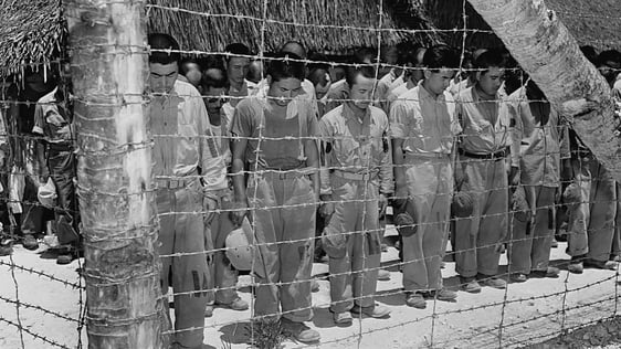 Japanese prisoners of war in an internment camp in Guam bow their heads after hearing Emperor Hiroh…