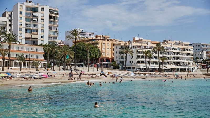 Tourists and locals at Figueretas beach on the Spanish island of Ibiza