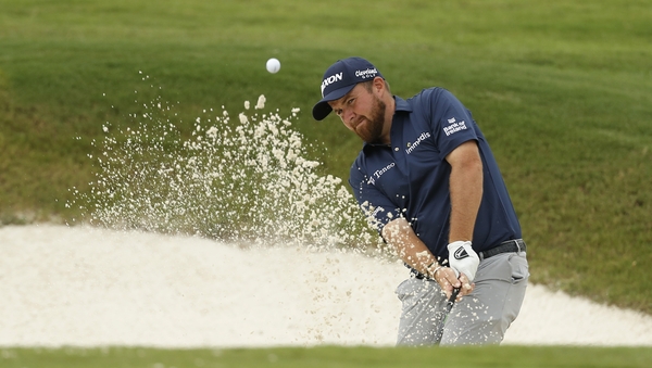 Shane Lowry plays a shot from a bunker on the 16th hole