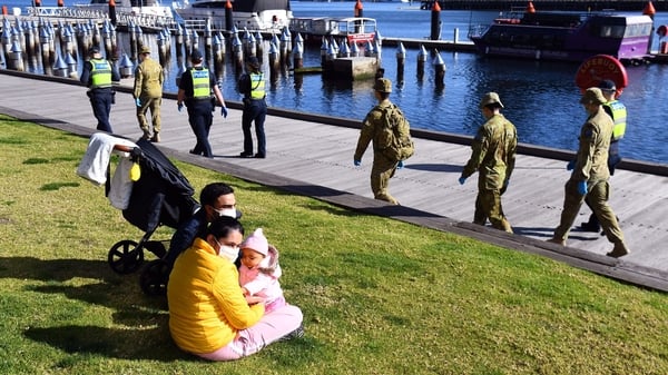 Police and soldiers patrol the docklands in Melbourne as increased restrictions come into effect
