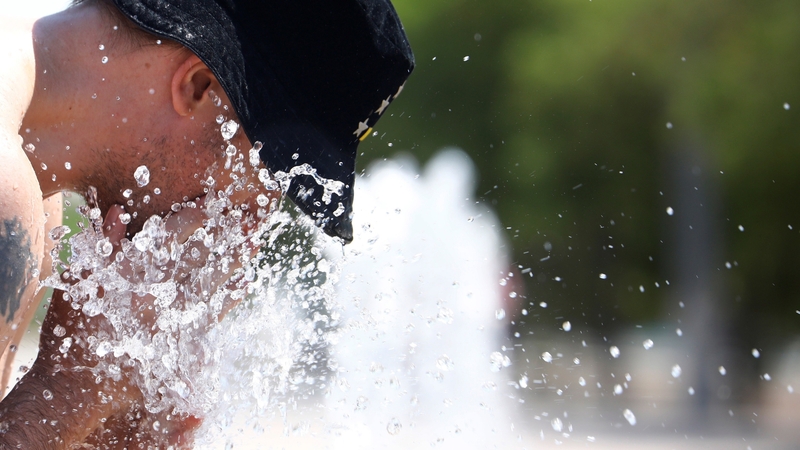 A man cools off at a public fountain in Cordoba, Spain