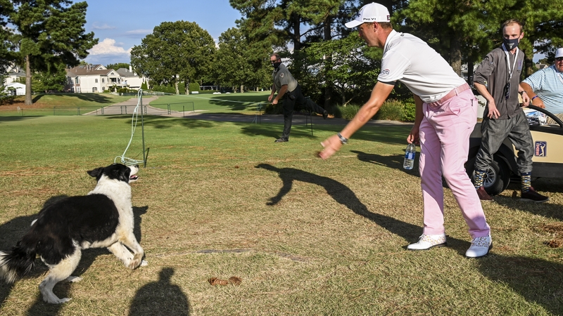 ustin Thomas plays with Millie, the border collie of the course superintendent, following his victory