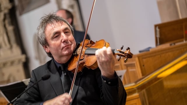 Frank Gallagher plays the violin during the funeral