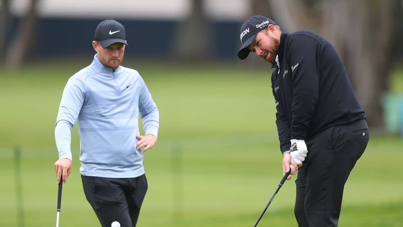 Shane Lowry plays a shot as Tom Lewis of England looks on during a practice round at TPC Harding Park