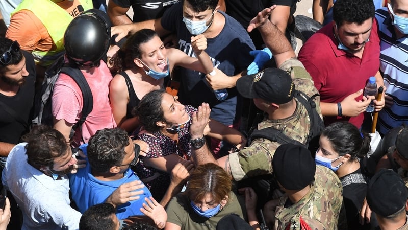 Lebanese anti-government protesters scuffle with security forces during the visit of French President Emmanuel Macron