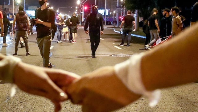 People hold hands during the protest against the election results