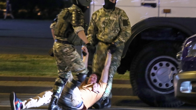 A man is seen being dragged by police during the protests