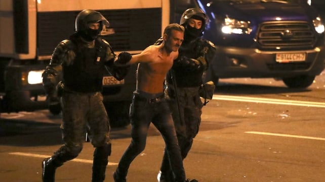 Riot police detain a man participating in a protest
