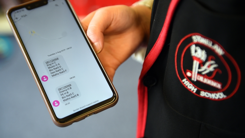A pupil at Stonlelaw High School in Rutherglen, Glasgow, shows a text message with her exam grades