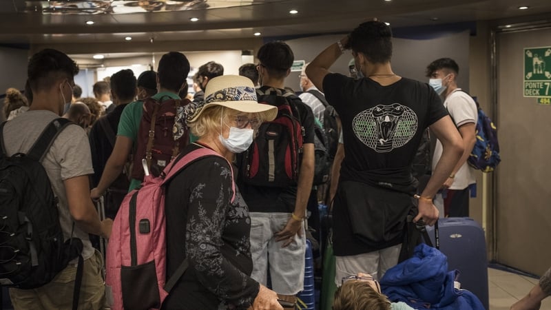 Passengers disembark from a ship from Greece at the port of Ancona, Italy