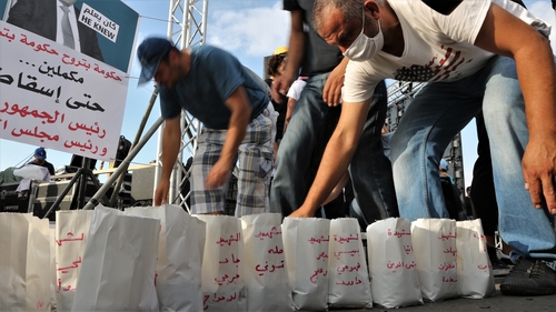 People gather near the devastated harbour area to commemorate the victims of the explosion last week