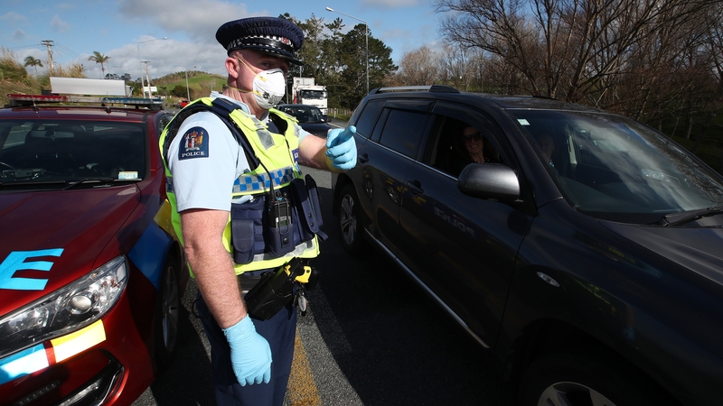 Police chat to drivers at a checkpoint in Auckland, New Zeland after new Covid restrictions were put in place
