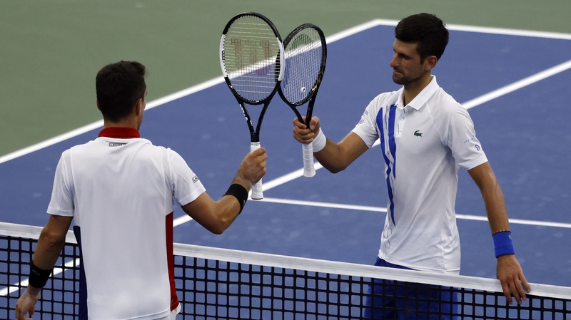 Novak Djokovic (R) taps racquets with Roberto Bautista Agut after defeating him