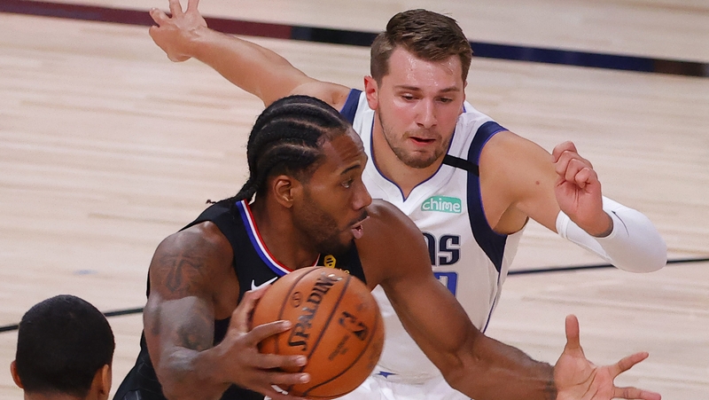 Kawhi Leonard #2 of the LA Clippers drives against Trey Burke #32 and Luka Doncic #77 of the Dallas Mavericks