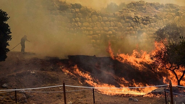 A firefighter works to put out a wildfire in the Peloponnese region of Greece