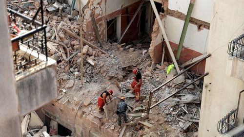 Rescue workers at the site of the collapsed building where a pulse was detected