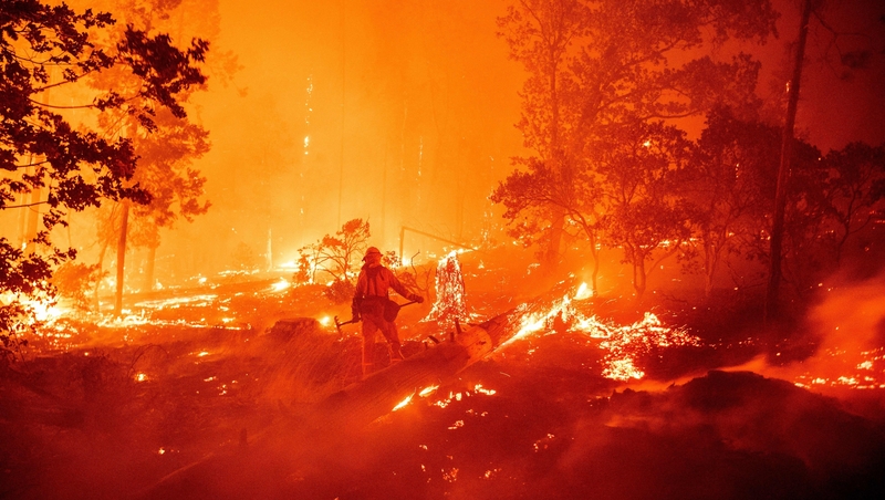 A firefighter tries to dampen flames as they push towards homes during the Creek fire in California