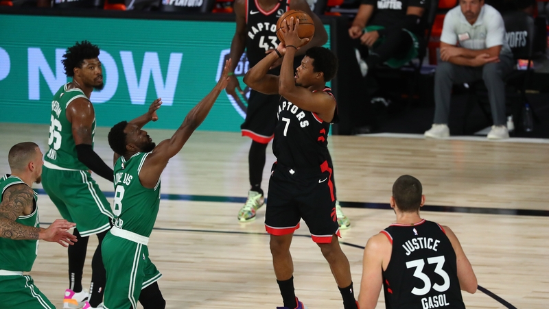 Kyle Lowry of the Toronto Raptors gets his shot off despite the best efforts of Kemba Walker of the Boston Celtics