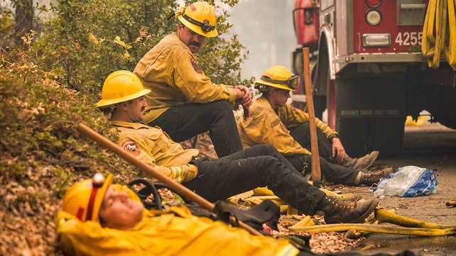 Firefighters Rob Spitzer, Max Kitty, Josiah Gist, and Hunter Grossmann with Cal Fire Madera Mariposa Merced Unit - Rancheria take a break along Waterfall Way in the Cascadel Woods community where he and his colleagues have been fighting the Creek