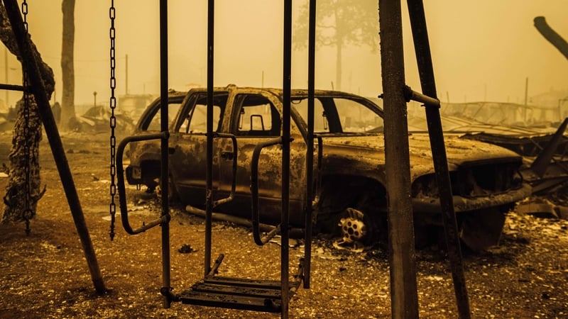A charred swing set and car are seen after the passage of the Santiam Fire in Gates, Oregon