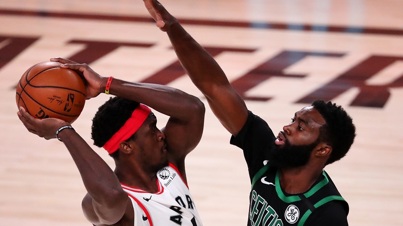 Pascal Siakam of the Toronto Raptors is challenged by the Boston Celtics' Jaylen Brown