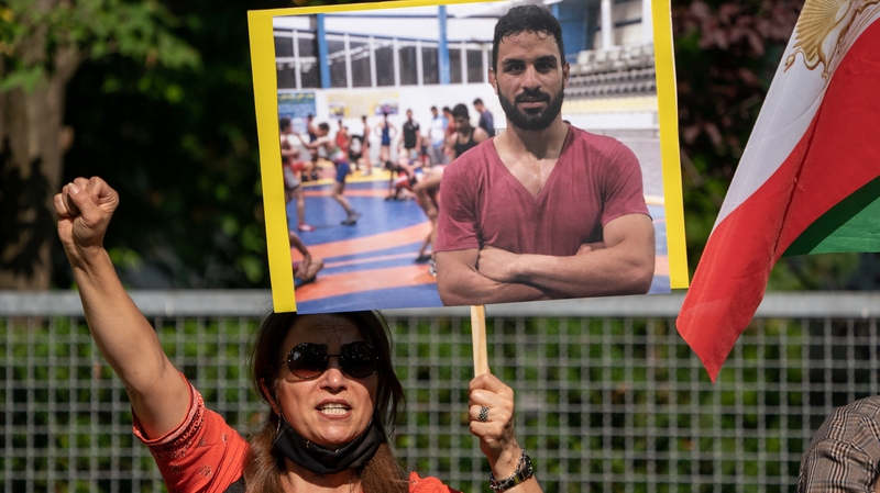 A protestor holds a placard with a picture of Navid Afkari