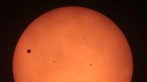 Venus, seen on the left, tracking across the Sun