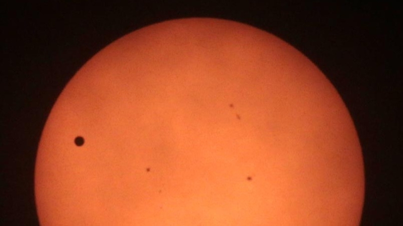 Venus, seen on the left, tracking across the Sun