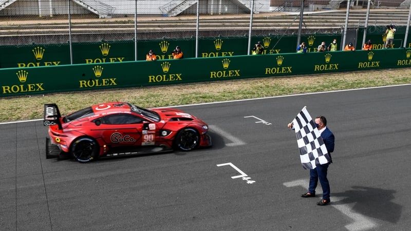 The Aston Martin car takes the checkered flag