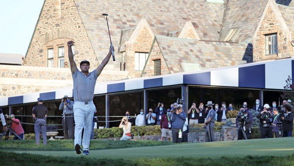 Bryson DeChambeau celebrates on the 18th green