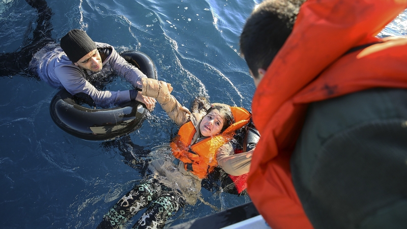 Turkish Coast Guard personnel help refugees en route to Greece in January 2016 (File photo)