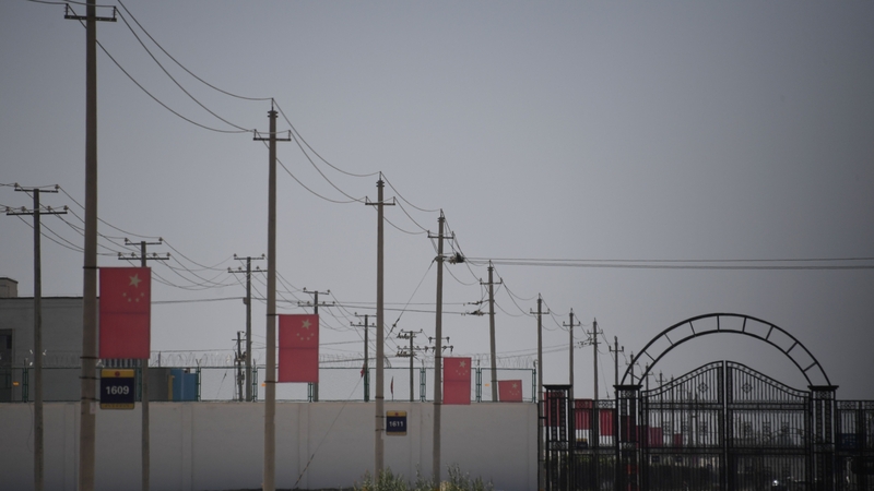 This photo taken in 2019 shows Chinese flags on a road leading to a facility believed to be a 're-education camp' where mostly Muslim ethnic minorities were detained