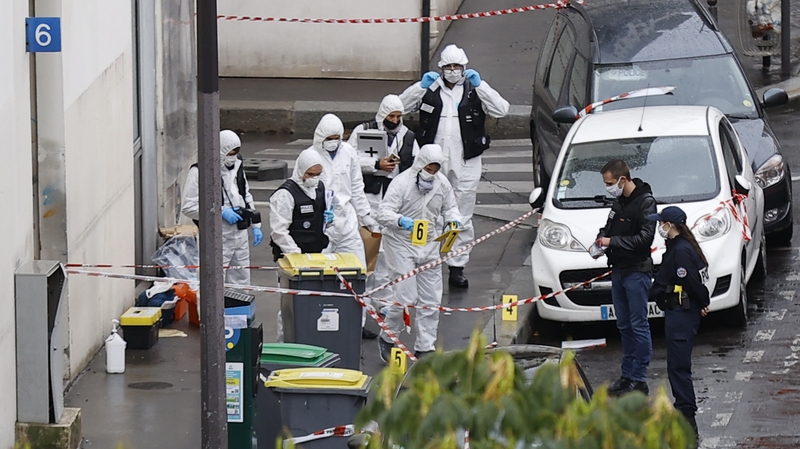 French forensic police investigators at the site of the meat cleaver attack near the former Charlie Hebdo offices in Paris