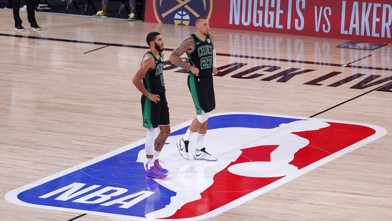 Jayson Tatum and Daniel Theis of the Boston Celtics react after their win