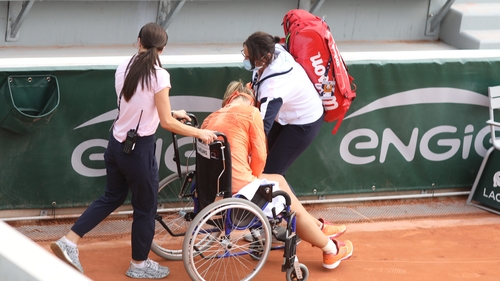 Kiki Bertens is taken off the court in a wheel chair