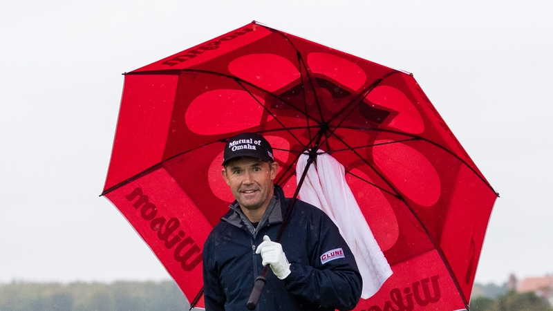 Padraig Harrington protects himself from the elements on day three