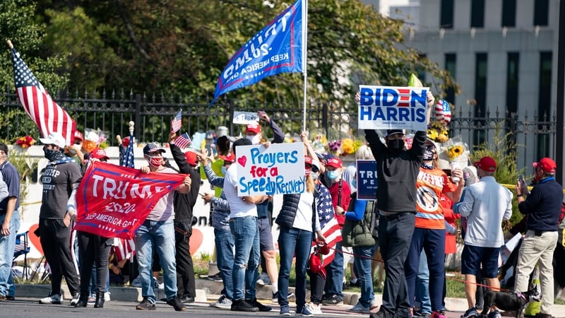 A single Biden-Harris supporter holds a sign as supporters of US President Donald Trump rally outside Walter Reed Medical Centre in Bethesda, Maryland