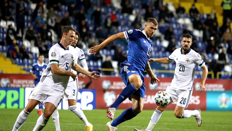 Bosnia and Herzegovina's Edin Dzeko (centre) battles for the ball with Northern Ireland's Jonny Evans