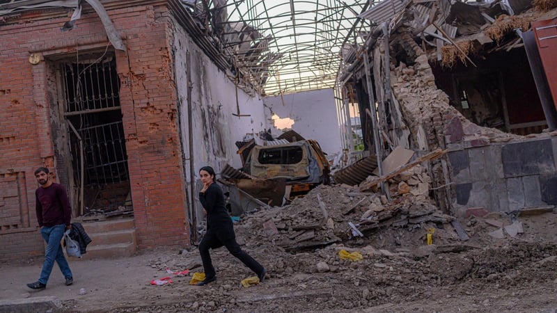 Local residents walk in a street after it was hit by a missile in Gandja, Azerbaijan
