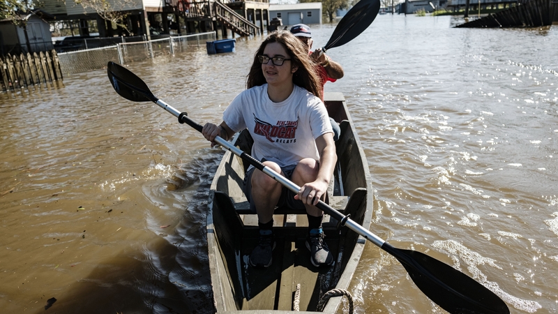Locals paddle through a flooded road in Delcambre, Louisiana, today