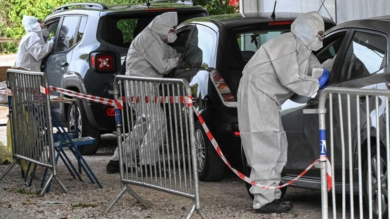 Firefighters wearing protective suits take samples to carry out tests at a drive-through Covid-19 screening centre in Montpellier