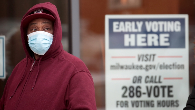 A man waits in line to vote in the Midtown neighbourhood of Milwaukee, Wisconsin