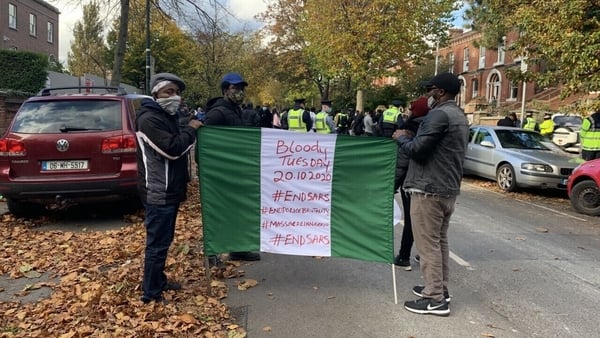 The protesters are ringing bells and waving Nigerian flags outside the embassy in Dublin