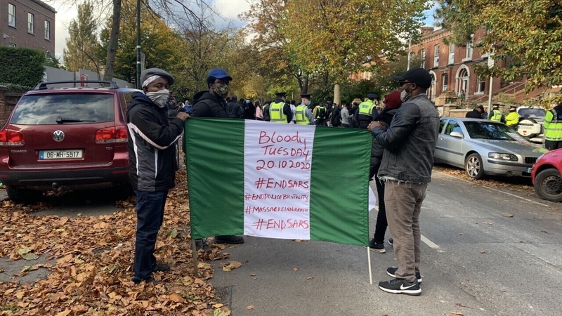 The protesters are ringing bells and waving Nigerian flags outside the embassy in Dublin