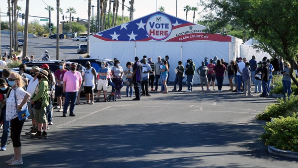 People queue to vote at a shopping centre on the first day of in-person voting on 17 October in Las Vegas, Nevada
