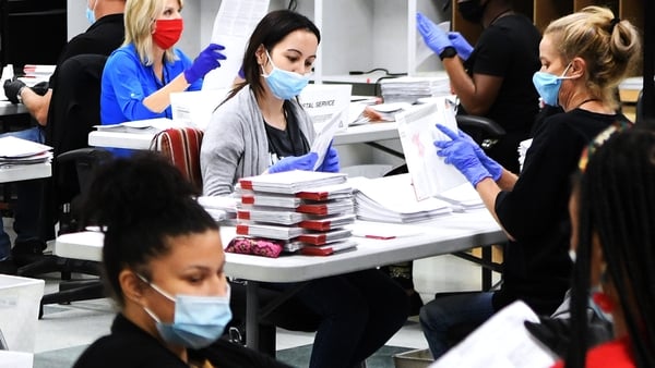 Election workers sort mail-in ballots at a centre in Orlando, Florida