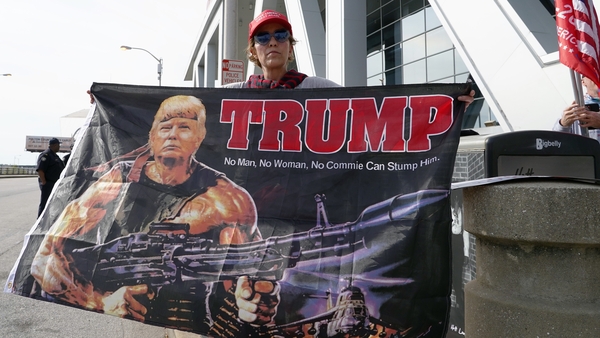 A Trump supporter holds a flag depicting the president as Rambo